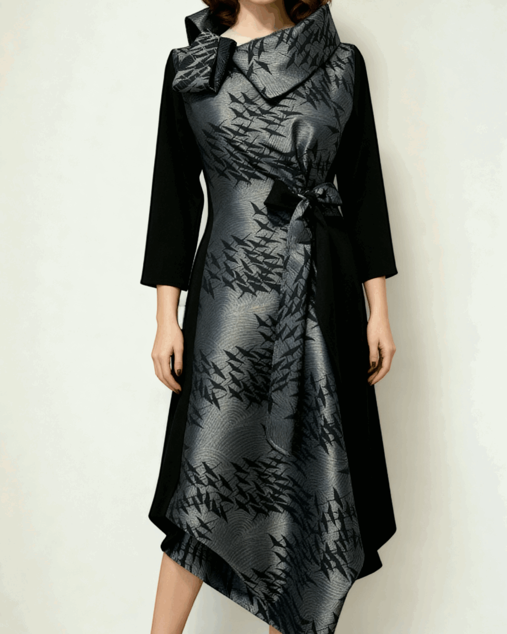 Model nosi elegantnu asimetričnu haljinu ARGENTA od srebrno-crnog brokata.