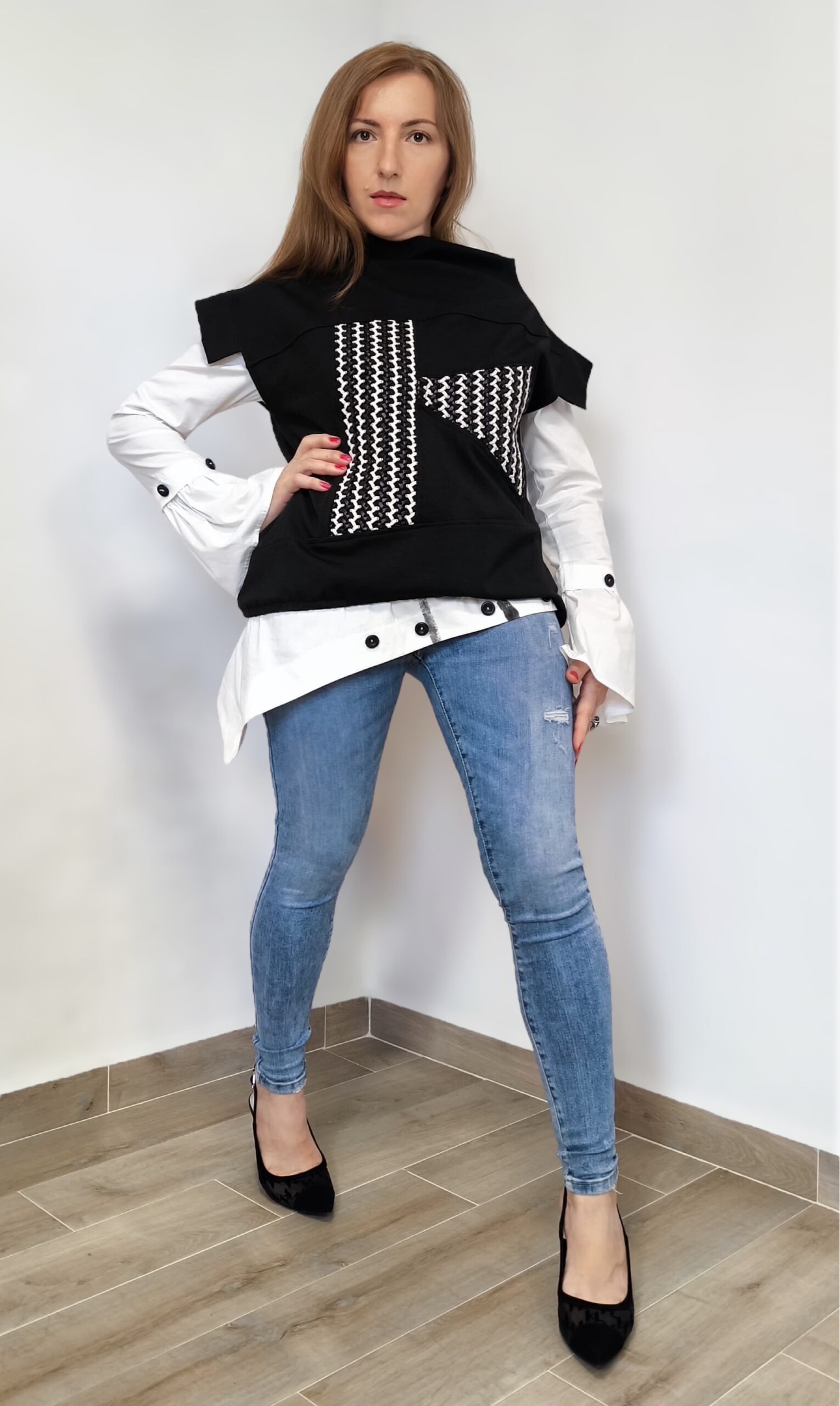 žena pozira u prsluku sa zanimljivim grafičkim uzorkom