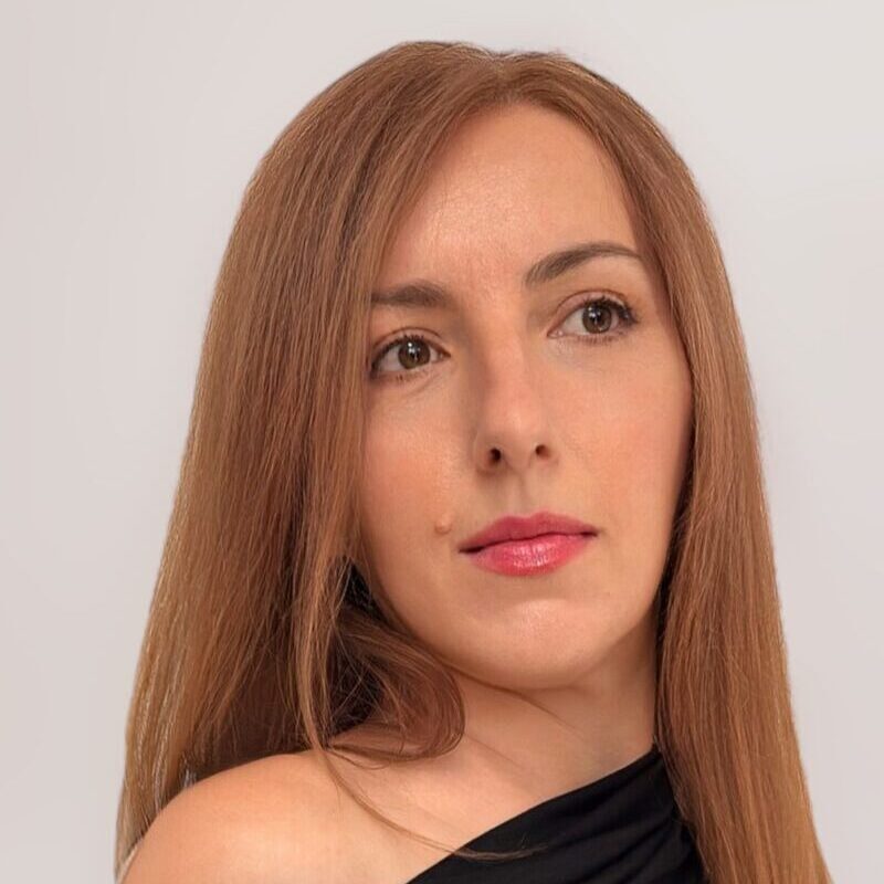 žena u elegantnoj crnoj off-shoulder haljini u minimalističkom okruženju