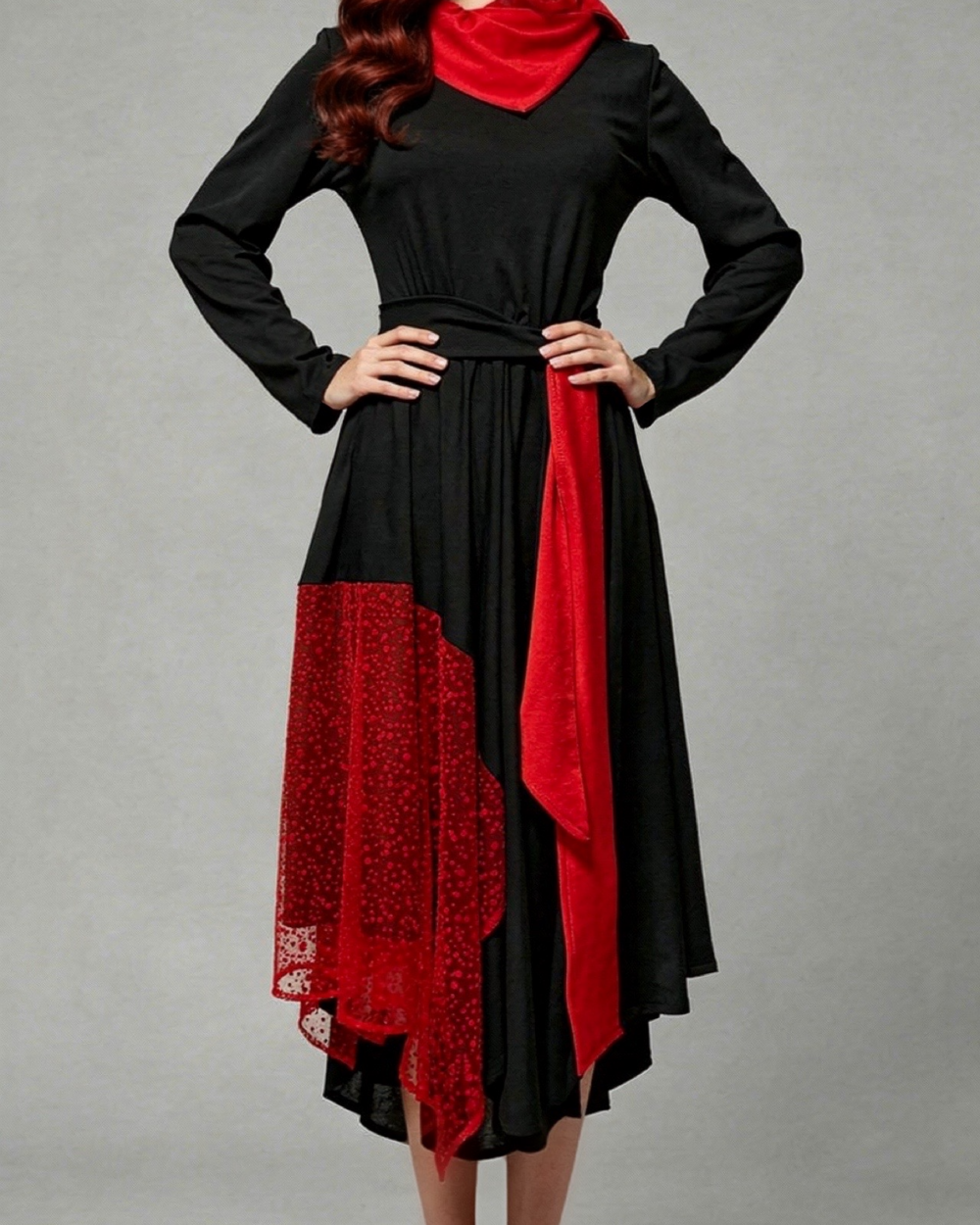 Žena nosi crno-crvenu asimetričnu haljinu BARBARA s pojasom i crvenim detaljima