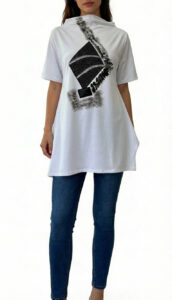 Ženski model nosi AXIS bijelu oversized tuniku s crnim geometrijskim printom u kombinaciji s trapericama.