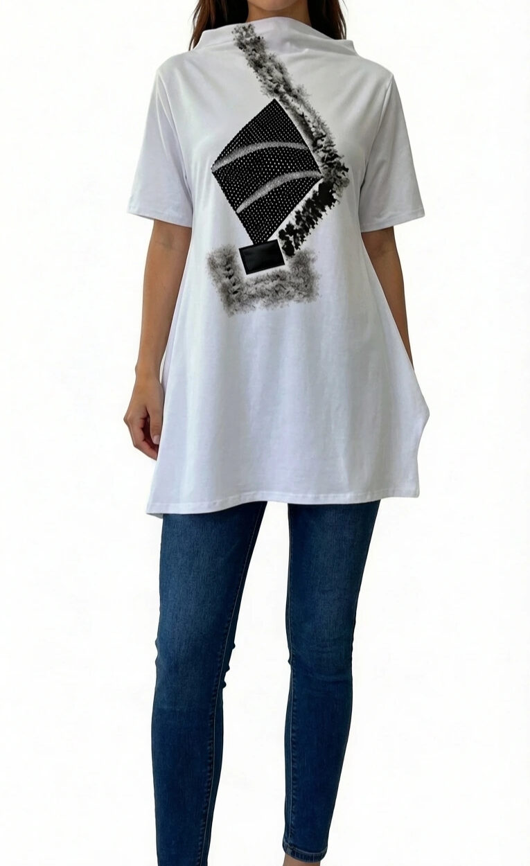 Ženski model nosi AXIS bijelu oversized tuniku s crnim geometrijskim printom u kombinaciji s trapericama.