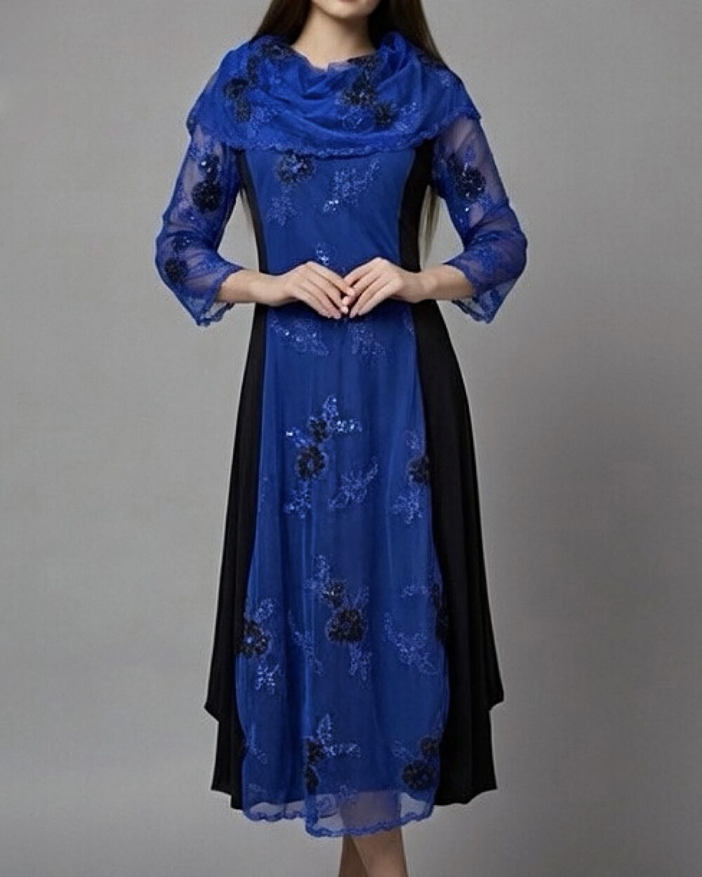 Model nosi svečanu midi haljinu Paulina u kombinaciji kraljevski plave i crne boje sa šal ovratnikom.