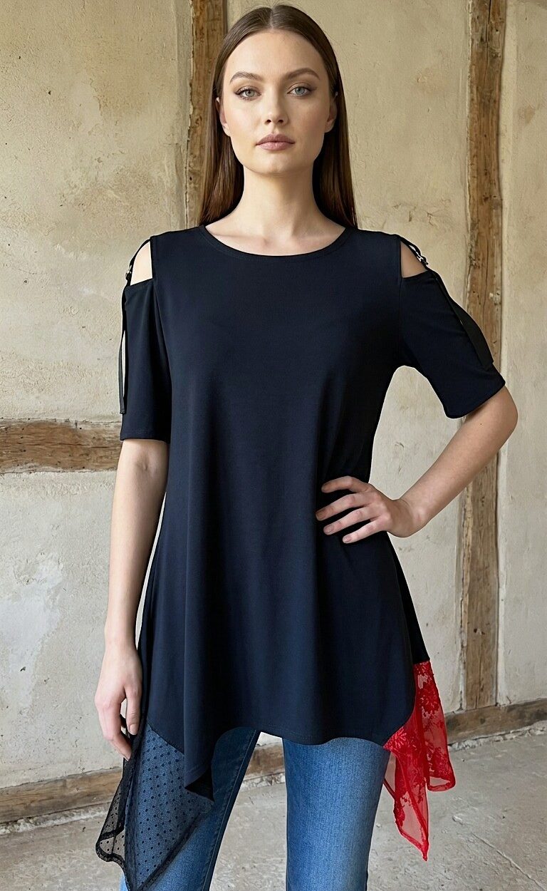Žena nosi elegantnu crnu tuniku DORIS asimetričnog kroja s crvenom čipkom i detaljima na ramenima, kombiniranu s plavim trapericama.